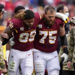 
              Washington Football Team defensive end Chase Young (99) is helped off the field by guard Brandon Scherff (75) after an injury during the first half of an NFL football game against the Tampa Bay Buccaneers, Sunday, Nov. 14, 2021, in Landover, Md. (AP Photo/Nick Wass)
            