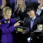 
              Actress Elizabeth Banks, middle left, presents the Breeders' Cup champion award to Lee Jinwoo, senior manager from Korea Racing Authority, after Knicks Go won the Breeders' Cup Classic race at the Del Mar racetrack in Del Mar, Calif., Saturday, Nov. 6, 2021. (AP Photo/Jae C. Hong)
            