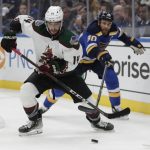 
              Arizona Coyotes' Shayne Gostisbehere (14) keeps the puck away from St. Louis Blues' Ryan O'Reilly (90) during the second period of an NHL hockey game Tuesday, Nov. 16, 2021 in St. Louis. (AP Photo/Tom Gannam)
            