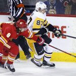 
              Calgary Flames' Christopher Tanev, left, reaches around Pittsburgh Penguins' Sidney Crosby during the first period of an NHL hockey game, Monday, Nov. 29, 2021 in Calgary, Alberta. (Larry MacDougal/The Canadian Press via AP)
            