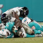 
              Miami Dolphins quarterback Jacoby Brissett (14) holds his knee after he was sacked by Baltimore Ravens outside linebacker Justin Houston during the second half of an NFL football game, Thursday, Nov. 11, 2021, in Miami Gardens, Fla. (AP Photo/Wilfredo Lee)
            