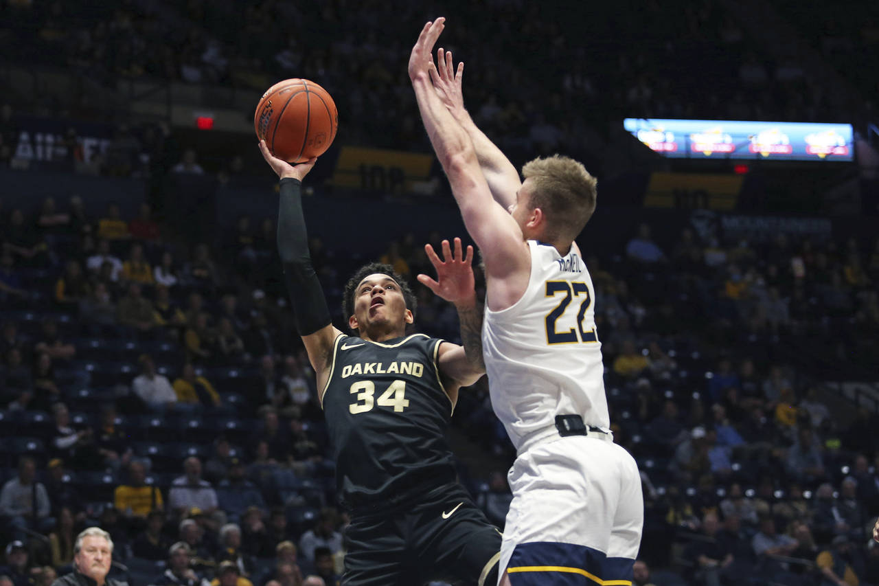 Oakland guard Jalen Moore (34) shoots as West Virginia guard Sean McNeil (22) defends during the fi...