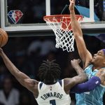 
              Minnesota Timberwolves forward Anthony Edwards (1) drives to the basket while guarded by Charlotte Hornets forward P.J. Washington during the first half of an NBA basketball game in Charlotte, N.C., Friday, Nov. 26, 2021. (AP Photo/Jacob Kupferman)
            