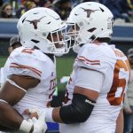 
              Texas running back Roschon Johnson (2) and offensive lineman Jake Majors (65) celebrate after a touchdown during the second half of an NCAA college football game against West Virginia in Morgantown, W.Va., Saturday, Nov. 20, 2021. (AP Photo/Kathleen Batten)
            