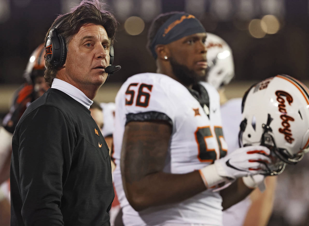 Oklahoma State coach Mike Gundy looks down the sideline during the second half of an NCAA college f...