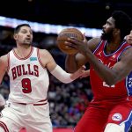 
              Philadelphia 76ers' Joel Embiid looks to shoot as Chicago Bulls' Nikola Vucevic (9) and Zach LaVine defend during the first half of an NBA basketball game Saturday, Nov. 6, 2021, in Chicago. (AP Photo/Charles Rex Arbogast)
            