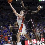 
              Florida forward Colin Castleton (12) is fouled by Troy forward Zay Williams (10) but makes a basket during the first half of an NCAA college basketball game Sunday, Nov. 28, 2021, in Gainesville, Fla. (AP Photo/Matt Stamey)
            