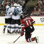 
              New Jersey Devils left wing Andreas Johnsson (11) reacts as the San Jose Sharks surround defenseman Erik Karlsson after his goal during the second period of an NHL hockey game Tuesday, Nov. 30, 2021, in Newark, N.J. (AP Photo/Bill Kostroun)
            