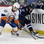 
              Winnipeg Jets' Jansen Harkins (12) and New York Islanders' Anders Lee (27) battle for the puck during the first period of NHL hockey game action in Winnipeg, Manitoba, Saturday, Nov. 6, 2021. (Fred Greenslade/The Canadian Press via AP)
            