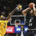 
              Eastern Kentucky forward Michael Moreno (24) shoots while defended by West Virginia guard Malik Curry (10) during the first half of an NCAA college basketball game in Morgantown, W.Va., Friday, Nov. 26, 2021. (AP Photo/Kathleen Batten)
            