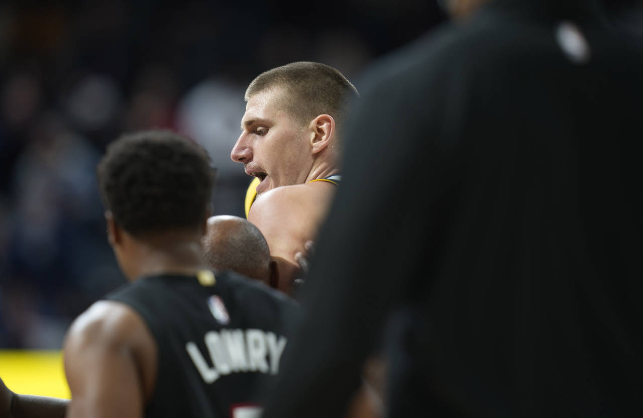 Denver Nuggets center Nikola Jokic, center, is restrained after getting into an altercation with Mi...