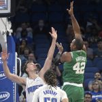
              Boston Celtics center Al Horford (42) shoots over Orlando Magic forward Franz Wagner, left, as guard Cole Anthony (50) watches during the first half of an NBA basketball game Wednesday, Nov. 3, 2021, in Orlando, Fla. (AP Photo/Phelan M. Ebenhack)
            