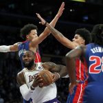 
              Los Angeles Lakers forward LeBron James, bottom left, drives between Detroit Pistons guard Cade Cunningham (2) and guard Killian Hayes (7) to the basket during the first half of an NBA basketball game Sunday, Nov. 28, 2021, in Los Angeles. (AP Photo/Alex Gallardo)
            