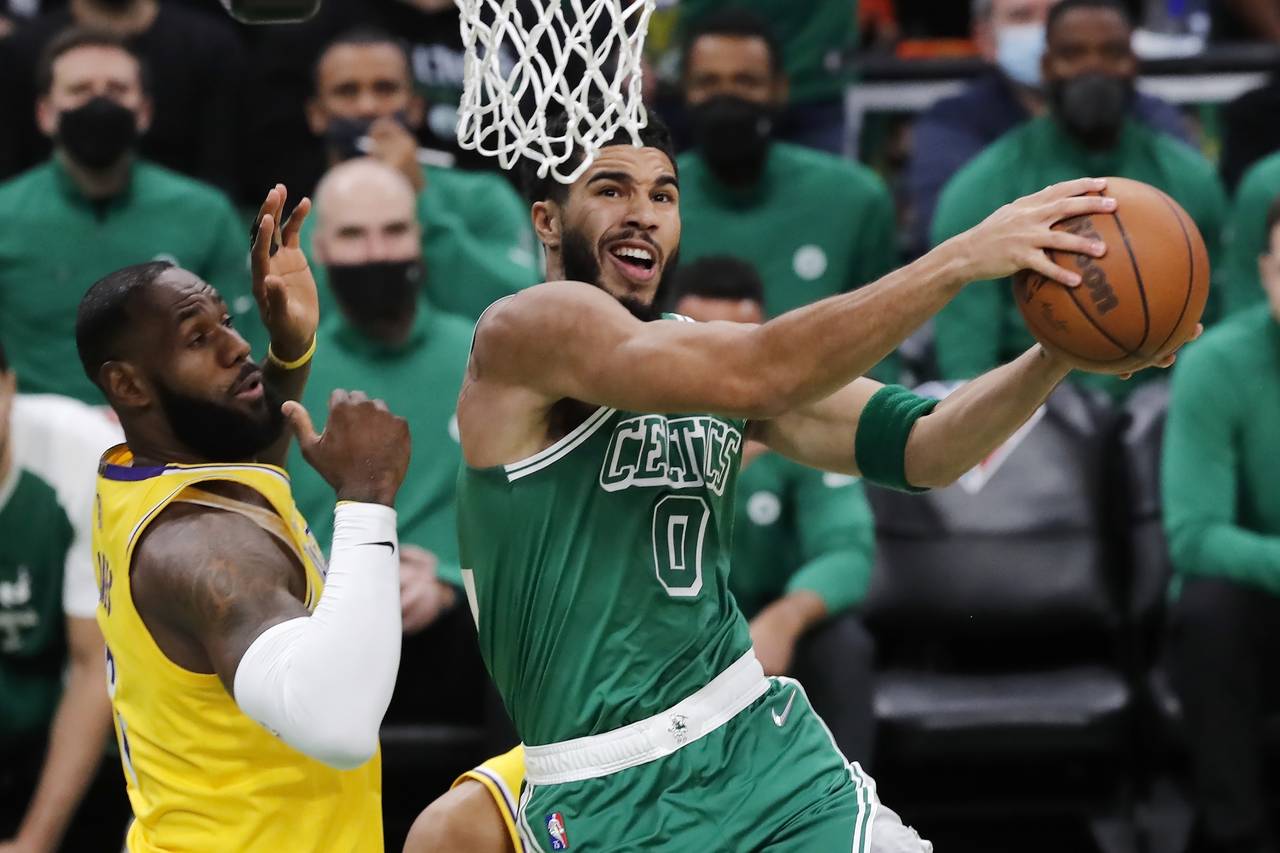 Boston Celtics' Jayson Tatum (0) goes up to shoot against Los Angeles Lakers' LeBron James, left, d...
