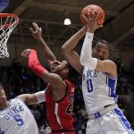 
              Duke forward Paolo Banchero (5) and forward Wendell Moore Jr. (0) battle Gardner-Webb guard Anthony Selden (23) for a rebound during the first half of an NCAA college basketball game Tuesday, Nov. 16, 2021, in Durham, N.C. (AP Photo/Chris Seward)
            