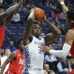 
              Kentucky's Oscar Tshiebwe (34) looks for an opening between Robert Morris' Enoch Cheeks (5) and Kahliel Spear, right, during the first half of an NCAA college basketball game in Lexington, Ky., Friday, Nov. 12, 2021. (AP Photo/James Crisp)
            