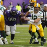 
              Green Bay Packers quarterback Aaron Rodgers (12) runs from Minnesota Vikings defensive tackle Sheldon Richardson (90) during the first half of an NFL football game, Sunday, Nov. 21, 2021, in Minneapolis. (AP Photo/Bruce Kluckhohn)
            