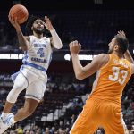 
              North Carolina's R.J. Davis (4) shoots over Tennessee's Uros Plavsic (33) in the second half of an NCAA college basketball game, Sunday, Nov. 21, 2021, in Uncasville, Conn. (AP Photo/Jessica Hill)
            
