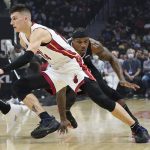 
              Miami Heat guard Tyler Herro, center, dribbles past Los Angeles Clippers guard Eric Bledsoe during the first half of an NBA basketball game Thursday, Nov. 11, 2021, in Los Angeles. (AP Photo/Marcio Jose Sanchez)
            