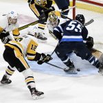 
              Pittsburgh Penguins goaltender Tristan Jarry (35) makes a save on Winnipeg Jets' Mark Scheifele (55) as Mike Matheson (5) and Zach Aston-Reese (12) defend during the second period of an NHL hockey game Monday, Nov. 22, 2021, in Winnipeg, Manitoba. (Fred Greenslade/The Canadian Press via AP)
            