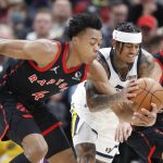 
              Toronto Raptors forward Scottie Barnes (4) and guard Malachi Flynn (22) fight for the ball with Utah Jazz guard Jordan Clarkson (00) during the first half of an NBA basketball game, Monday, Nov. 18, 2021, in Salt Lake City. (AP Photo/George Frey)
            