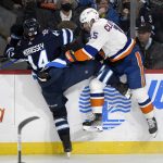 
              Winnipeg Jets' Josh Morrissey (44) collides with New York Islanders' Cal Clutterbuck (15) during the second period of NHL hockey game action in Winnipeg, Manitoba, Saturday, Nov. 6, 2021. (Fred Greenslade/The Canadian Press via AP)
            