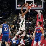 
              Milwaukee Bucks forward Giannis Antetokounmpo, of Greece, dunks on Washington Wizards forwards Kyle Kuzma, bottom left, and Deni Avdija, of Israel, in the second half of an NBA basketball game, Sunday, Nov. 7, 2021, in Washington. (AP Photo/Patrick Semansky)
            