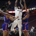 
              Oklahoma State's Bryce Thompson makes a basket between UMass Lowell's Kalil Thomas, left, and Everette Hammond, right, in the second half of an NCAA college basketball game, Tuesday, Nov. 16, 2021, in Uncasville, Conn. (AP Photo/Jessica Hill)
            