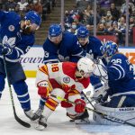 
              Toronto Maple Leafs' Jake Muzzin (8), Justin Holl (3) and Auston Matthews (34) team up to defend as goaltender Jack Campbell (36) makes a save on Calgary Flames' Andrew Mangiapane (88) during the third period of an NHL hockey game in Toronto on Friday, Nov. 12, 2021. (Frank Gunn/The Canadian Press via AP)
            