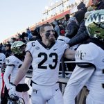 
              Wake Forest tight end Brandon Chapman (23) joins teammates as they celebrate with fans in the stands after defeating Boston College in an NCAA college football game, Saturday, Nov. 27, 2021, in Boston. (AP Photo/Mary Schwalm)
            