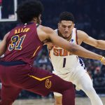 
              Phoenix Suns' Devin Booker (1) drives on Cleveland Cavaliers' Jarrett Allen (31) during the first half of an NBA basketball game Wednesday, Nov. 24, 2021, in Cleveland. (AP Photo/Tony Dejak)
            