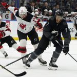 
              Tampa Bay Lightning right wing Mathieu Joseph (7) moves the puck around New Jersey Devils center Yegor Sharangovich (17) and center Janne Kuokkanen (59) during the second period of an NHL hockey game Saturday, Nov. 20, 2021, in Tampa, Fla. (AP Photo/Chris O'Meara)
            