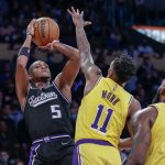 
              Sacramento Kings guard De'Aaron Fox (5) shoots while defended by Los Angeles Lakers guard Malik Monk (11) during the second half of an NBA basketball game in Los Angeles, Friday, Nov. 26, 2021. The Kings won 141-137 in triple overtime. (AP Photo/Ringo H.W. Chiu)
            