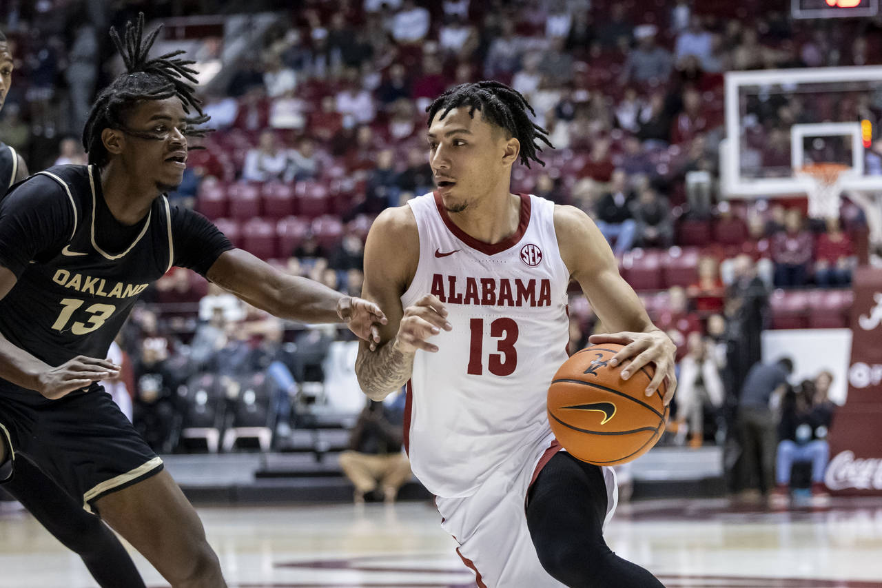 Alabama guard Jahvon Quinerly (13) works the ball around Oakland guard Osei Price (13) during the f...