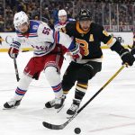 
              New York Rangers' Ryan Lindgren (55) tries to hold off Boston Bruins' David Pastrnak during the first period of an NHL hockey game Friday, Nov. 26, 2021, in Boston. (AP Photo/Winslow Townson)
            