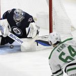 
              Winnipeg Jets' goaltender Eric Comrie (1) makes a save on Dallas Stars' Tanner Kero (64) during the first period of an NHL hockey game Tuesday, Nov. 2, 2021, in Winnipeg, Manitoba. (Fred Greenslade/The Canadian Press via AP)
            