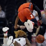 
              Illinois' Trent Frazier, top, jumps over Cincinnati's Mike Saunders as they chased after a loose ball during the first half of an NCAA college basketball game Monday, Nov. 22, 2021, in Kansas City, Mo. (AP Photo/Charlie Riedel)
            