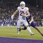 
              Washington State running back Max Borghi (21) scores a touchdown ahead of Washington defensive back Alex Cook, right during the second half of an NCAA college football game, Friday, Nov. 26, 2021, in Seattle. (AP Photo/Ted S. Warren)
            