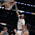 
              Los Angeles Lakers forward Anthony Davis, second from right, dunks against San Antonio Spurs forward Drew Eubanks, left, guard Devin Vassell, second from left, and forward Doug McDermott, right, during the first half of an NBA basketball game Sunday, Nov. 14, 2021, in Los Angeles. (AP Photo/Alex Gallardo)
            