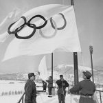 
              FILE - Members of Japan's self defense ground forces raise Olympic Flags on Sunday, Jan. 23, 1972, in Sapporo at Makomanai speed skating stadium in rehearsal of ceremony to take place February 3 at official opening of Winter Olympic. The northern Japanese city of Sapporo is set to announce on Monday, Nov. 29, 2021, what it says will be a reduction in costs that will make it an attractive venue for the 2030 Winter Olympics. (AP Photo/Mitsunori Chigita, File)
            