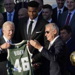 
              President Joe Biden holds a jersey presented to him by owner Marc Lasry during an event to welcome the Milwaukee Bucks basketball team to the White House to celebrate their 2021 NBA Championship, on the South Lawn of the White House in Washington, Monday, Nov. 8, 2021. In the center is Giannis Antetokounmpo. (AP Photo/Susan Walsh)
            
