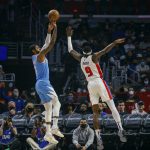 
              Los Angeles Clippers forward Paul George, left, shoots against Detroit Pistons forward Jerami Grant during the first half of an NBA basketball game, Friday, Nov. 26, 2021, in Los Angeles. (AP Photo/Ringo H.W. Chiu)
            