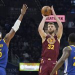 
              Cleveland Cavaliers' Dean Wade (32) shoots against Golden State Warriors' Kevon Looney (5) and Draymond Green (23) in the first half of an NBA basketball game, Thursday, Nov. 18, 2021, in Cleveland. (AP Photo/Tony Dejak)
            