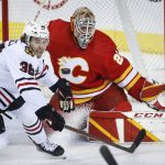 
              Chicago Blackhawks' Brandon Hagel, left, scrambles for the puck as Calgary Flames goalie Jacob Markstrom watches during the first period of an NHL hockey game Tuesday, Nov. 23, 2021, in Calgary, Alberta. /The Canadian Press via AP)
            