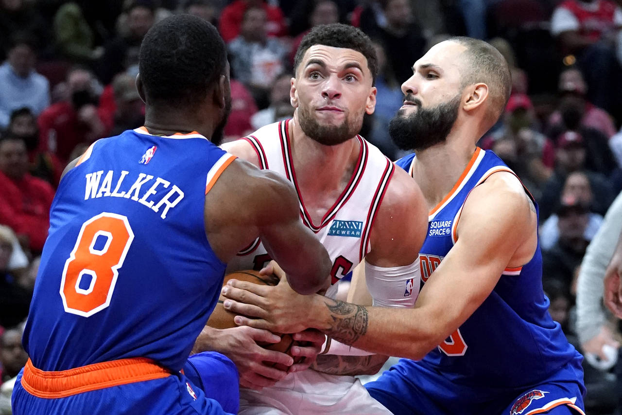 Chicago Bulls guard Zach LaVine, center, battles for the ball against New York Knicks guards Kemba ...
