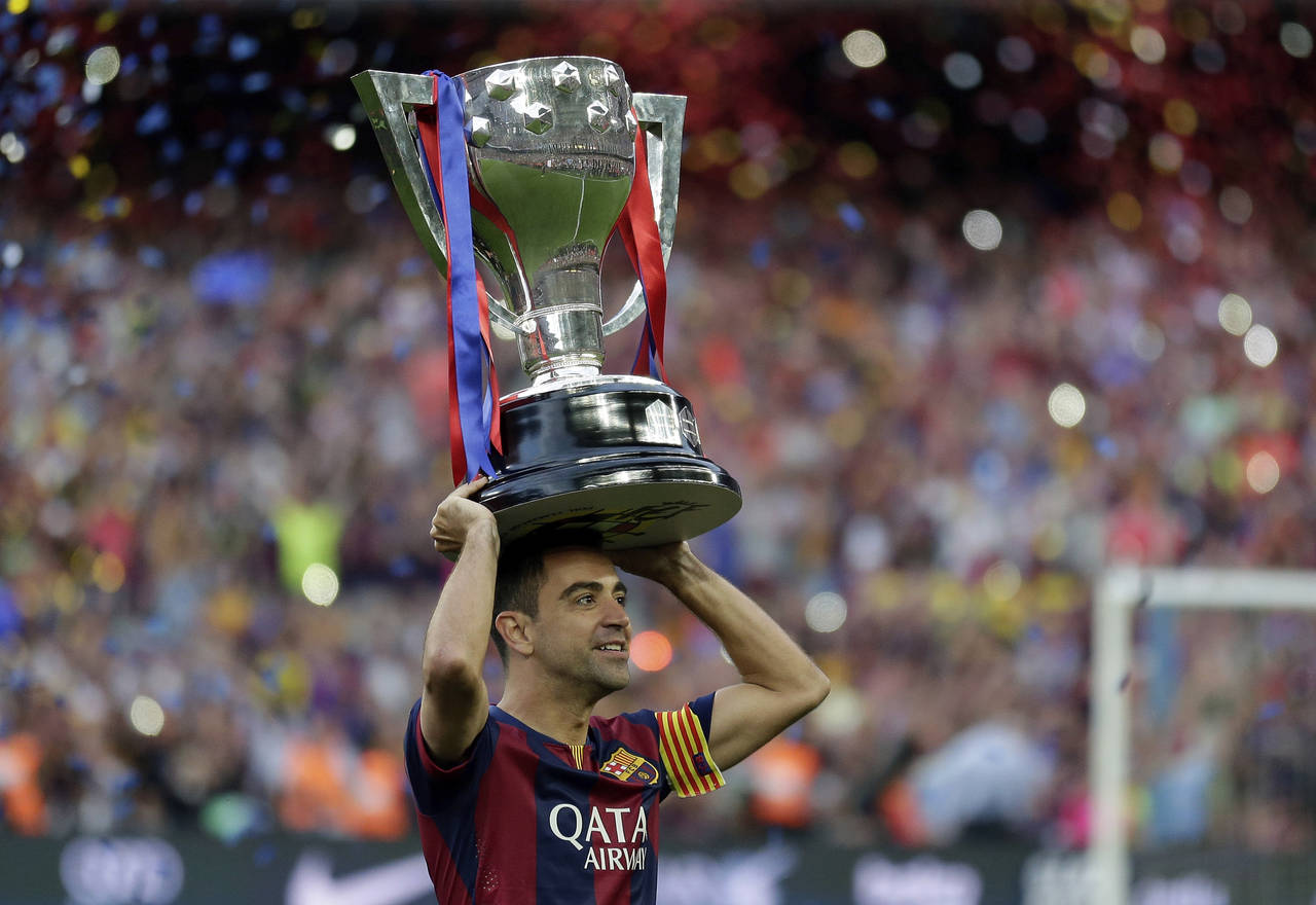 FILE - FC Barcelona's Xavi Hernandez holds up the trophy after winning the Spanish League title at ...