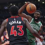 
              Boston Celtics' Jaylen Brown, right, scores as Toronto Raptors' Pascal Siakam looks on during first-half NBA basketball game action in Toronto, Sunday, Nov. 28, 2021. (Chris Young/The Canadian Press via AP)
            