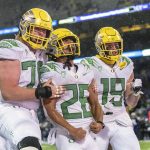
              Oregon running back Travis Dye (26), tight end Terrance Ferguson (19) and offensive lineman Dawson Jaramillo celebrate after Dye scored a touchdown during the second half of an NCAA college football game against the Washington, Saturday, Nov. 6, 2021, in Seattle. (AP Photo/Stephen Brashear)
            