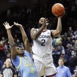 
              Connecticut's R.J. Cole, right, drives to the basket against LIU's Tre Wood, left, during the first half of an NCAA college basketball game Wednesday, Nov. 17, 2021, in Storrs, Conn. (AP Photo/Paul Connors)
            