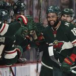 
              Minnesota Wild left wing Jordan Greenway (18) smiles while greeting teammates after scoring his first goal of the season, against the Arizona Coyotes during the second period of an NHL hockey game Tuesday, Nov. 30, 2021, in St. Paul, Minn. (AP Photo/Stacy Bengs)
            